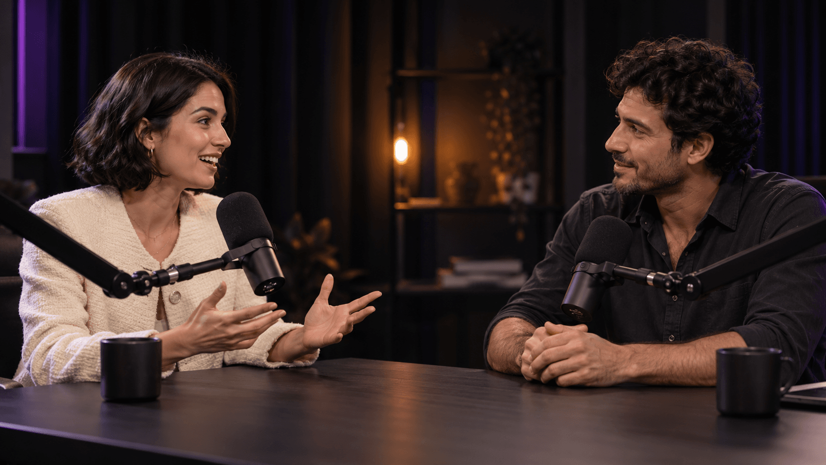 A guest and host in conversation at separate microphones in a cinematic podcast studio